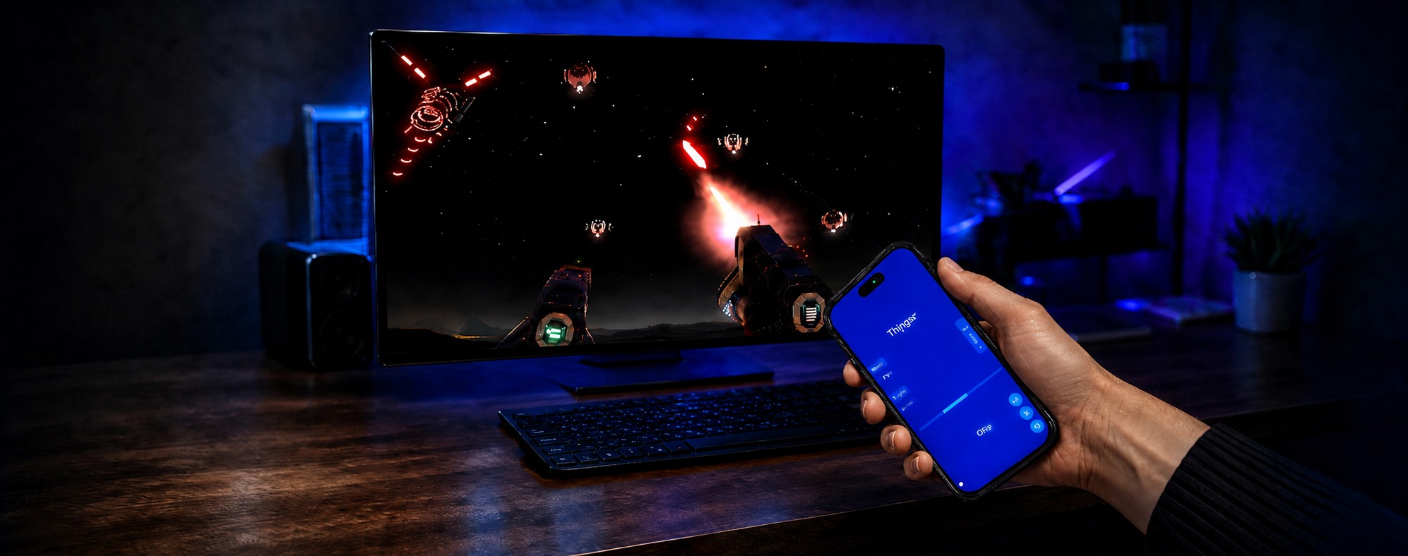 A hand holds a smartphone showing PortalVR Motion's on-screen controller in front of a desktop monitor running a SteamVR space shooter in a dimly lit room.